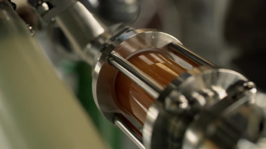 A metal machine with a cylinder filled with liquid swirling around