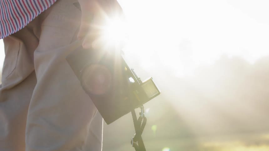 A person is carrying a camera on the field