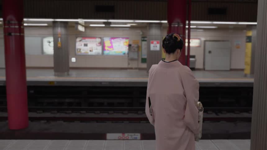 Woman stands in an empty train station