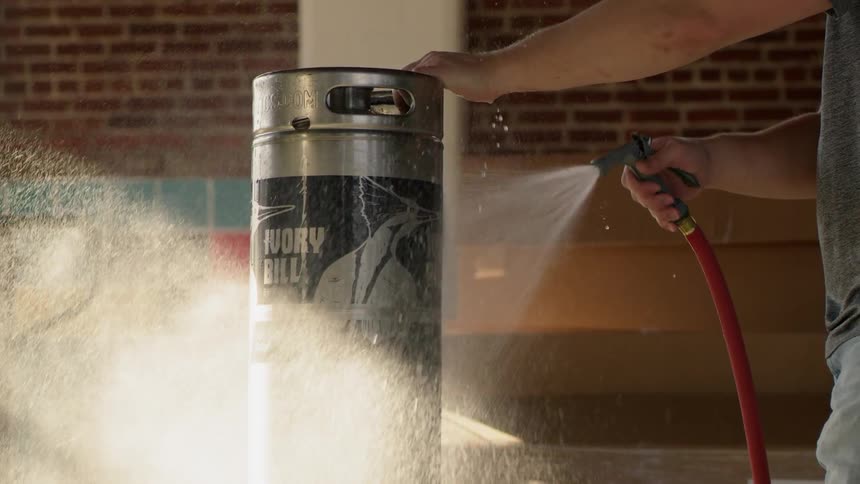 Man sprays water on a silver container