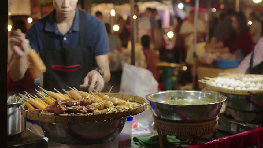 Man removes food from a pot and piles it on a large bowl