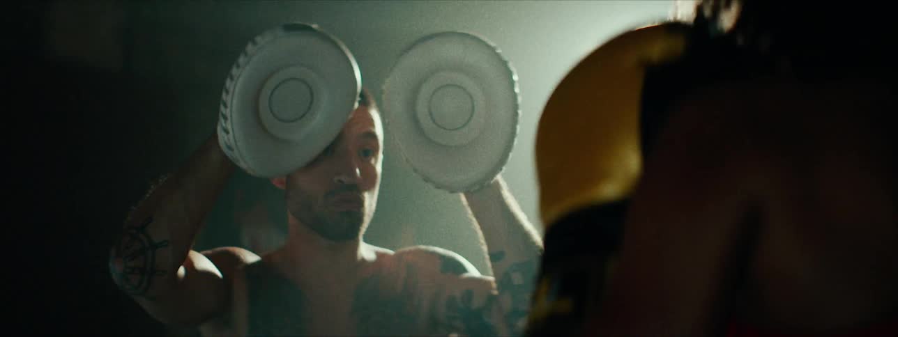 A man is practicing his boxing punches with a partner