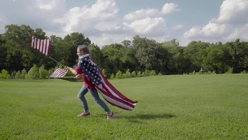 A child races across the field with American flags