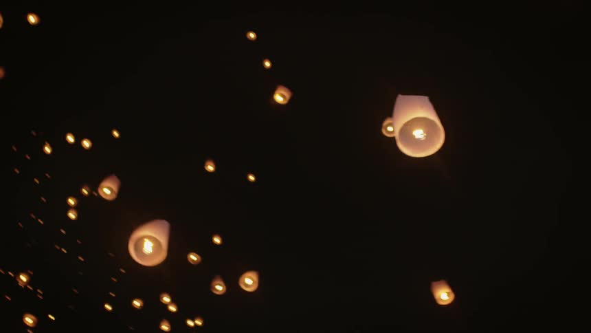 Paper lanterns float in the night sky