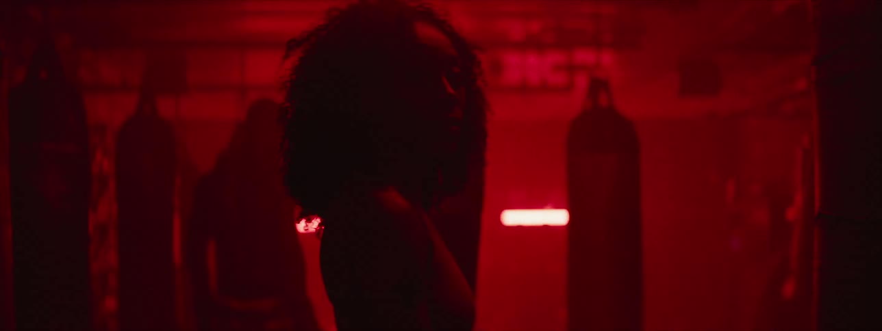 Man glances at woman as he walks towards a punching bag