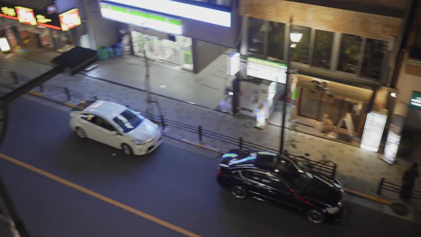 Vehicles travel on the city street at night