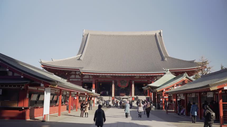 People walk toward a traditional Japanese shrine building