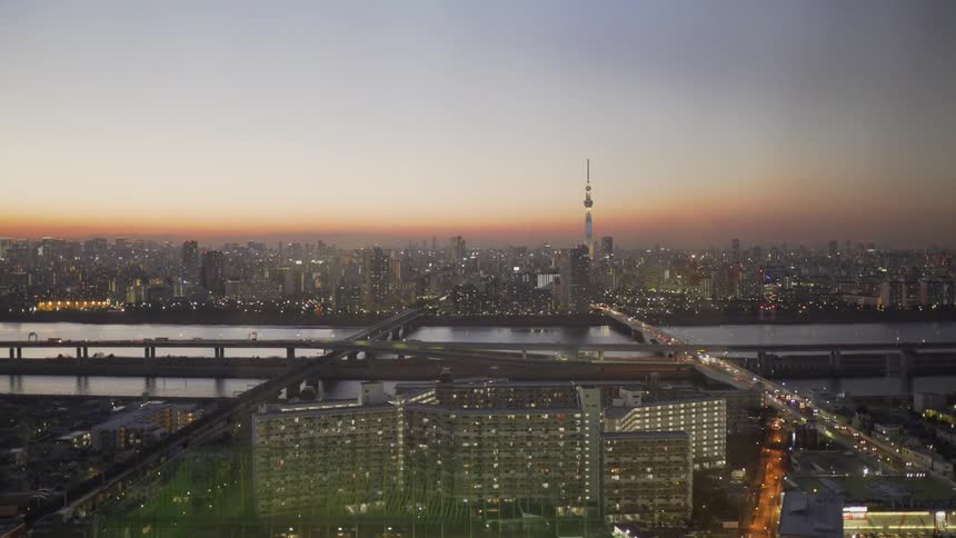 Cars drive on a city bridge at sunset