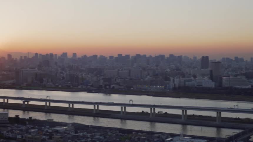 Cars travel on a city bridge at sunset
