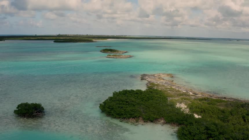 Calm water surrounds the islands under a cloudy sky
