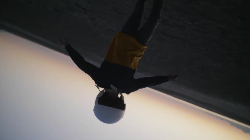 A boy runs in the desert with his arms outspread as the camera rotates