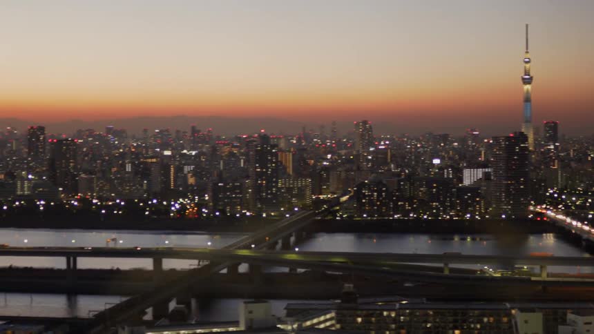 Vehicles cross the city bridge at dusk