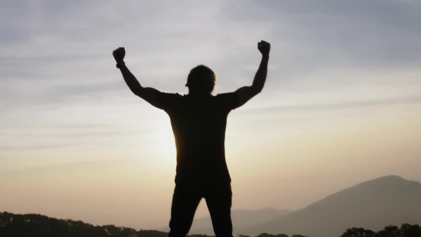 A man lifts his hands up in triumph