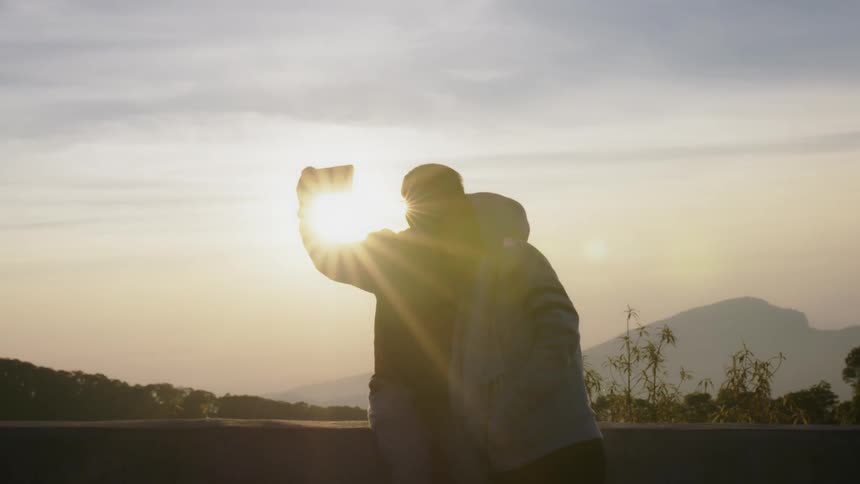 A man and woman take a selfie outside