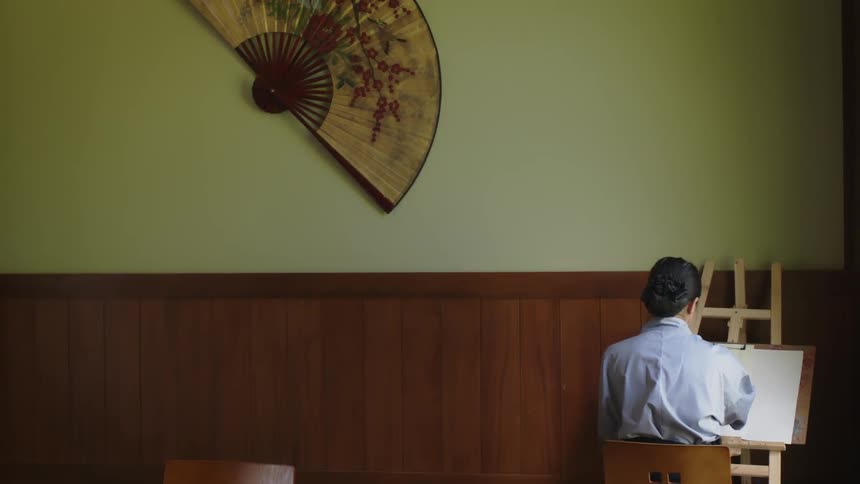 A person draws on an easel in the room