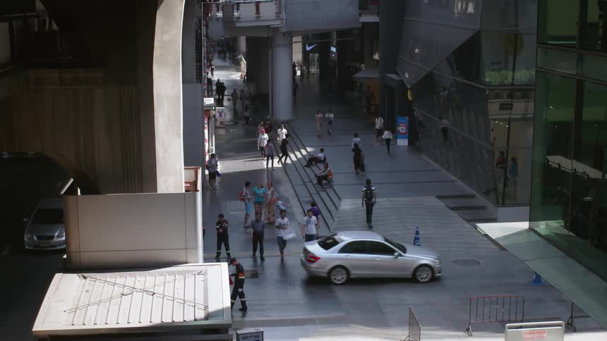 Car travels down the road before the pedestrians cross
