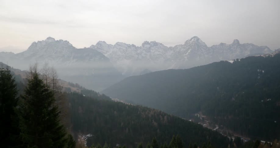 Panning view of majestic mountains on a somewhat cloudy day at sunset