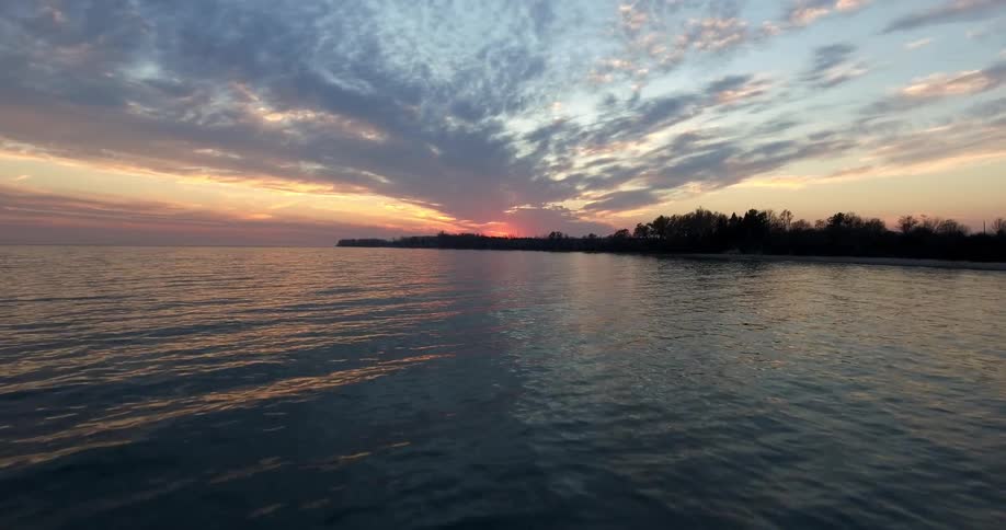 The long expanse of water leads to the shore at sunset