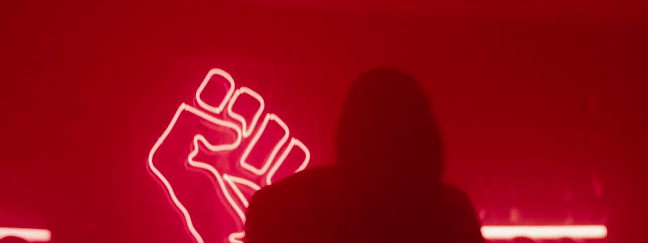 A man is shadow boxing in a dark room by a light of a fist