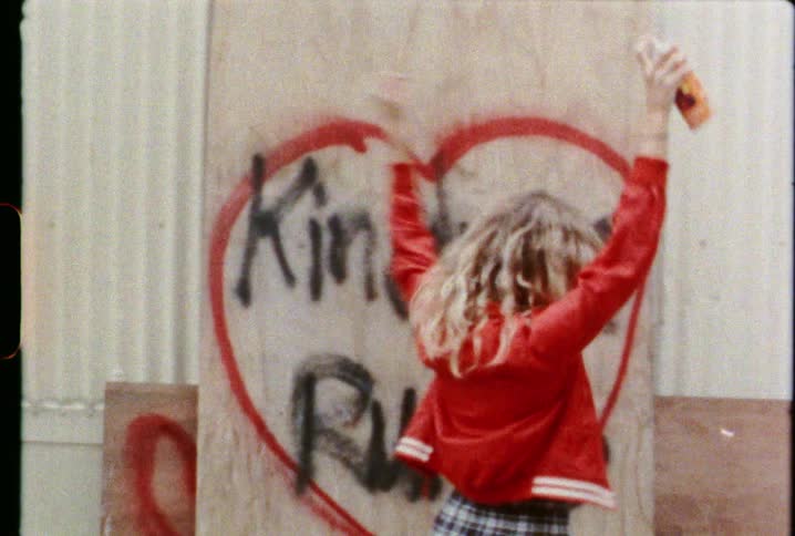 A woman sprays graffiti on the wall