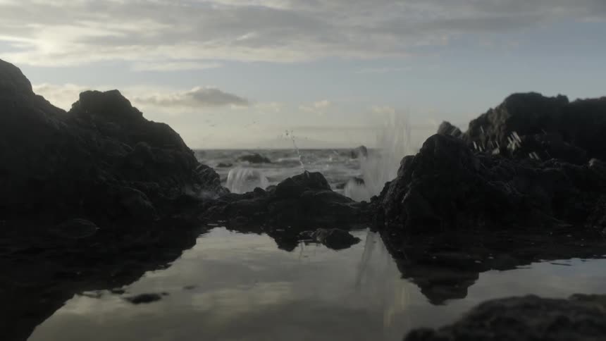 Ocean waves crash into a rocky shore