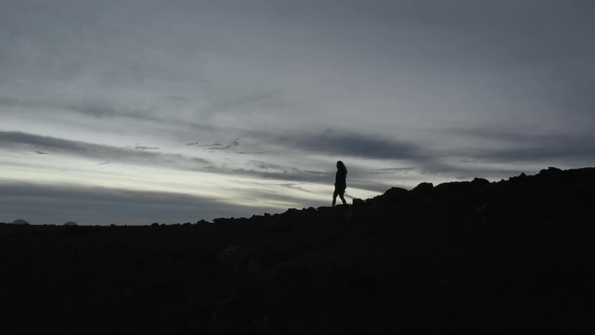 A woman descends from a hill
