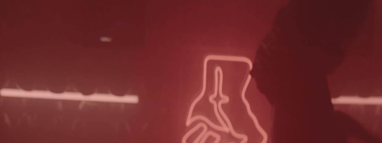 A man is shadow boxing in a red dimly lit room