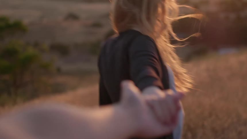 Woman releases someone's hand as she walks away under the sun