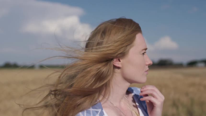 A woman's hair is blown briskly by the wind