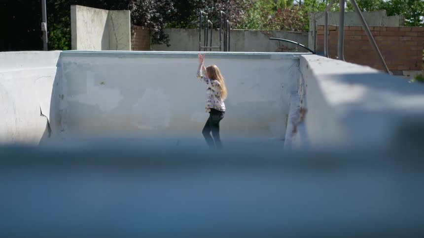 A woman is dancing in the pool on a sunny day
