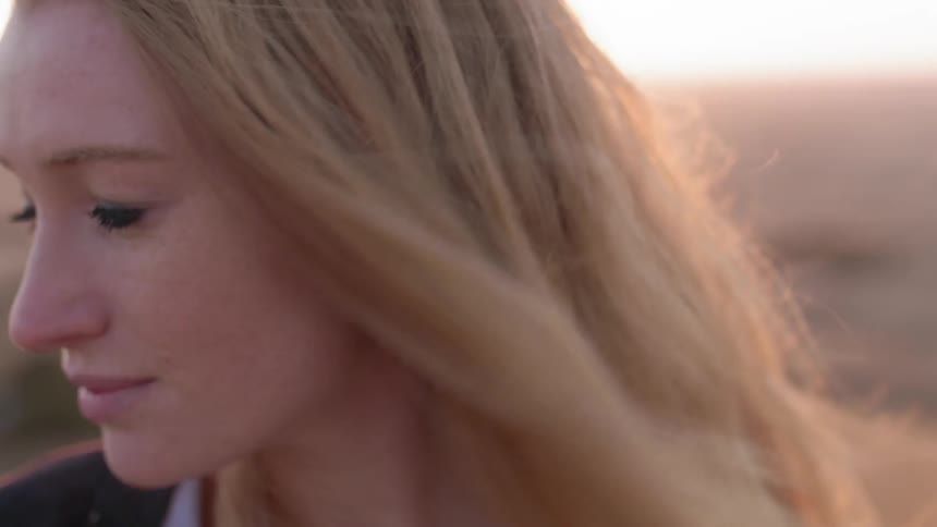 A woman's blond hair is blown by the wind