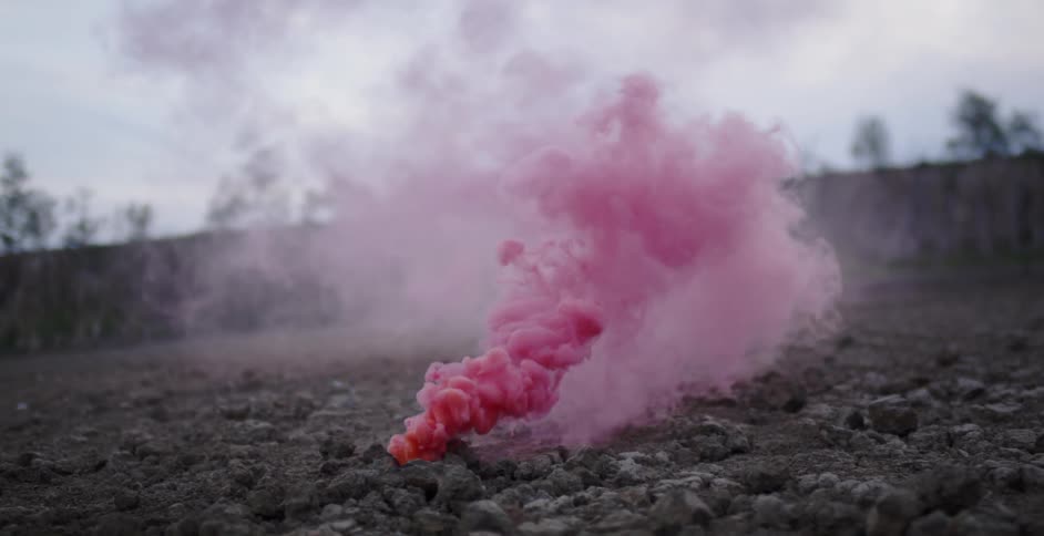 Pink smoke billows out from the ground