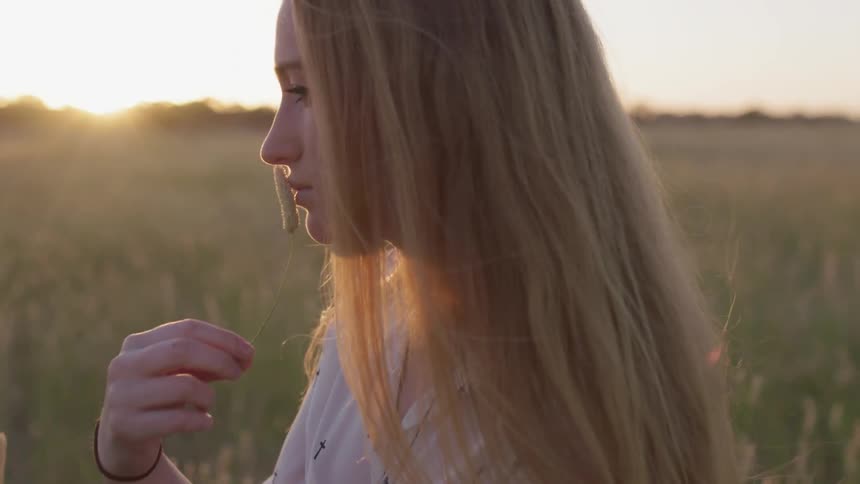 Woman stands in windy field