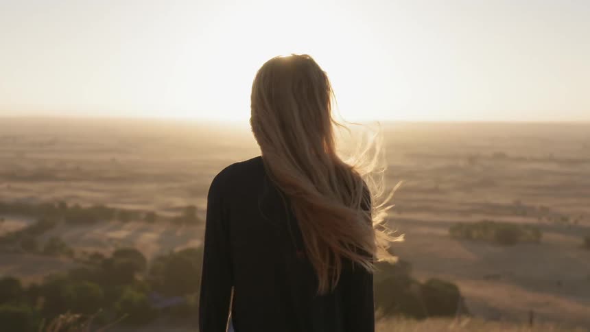A woman hikes outside on a windy day