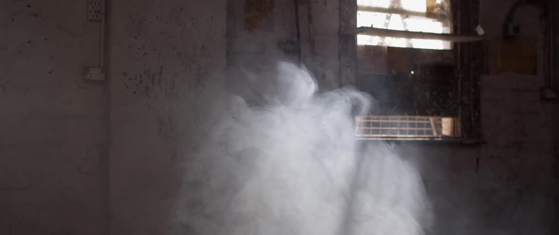 Smoke floats and swirls in a warehouse