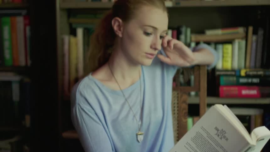 A woman reads a book at a chair