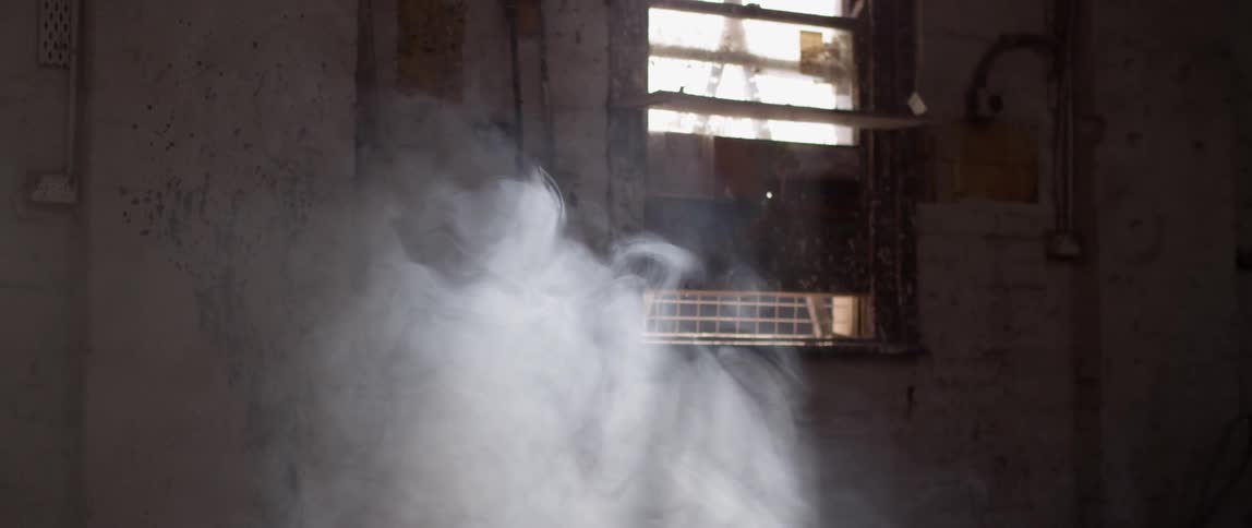 Smoke floats and swirls in a warehouse