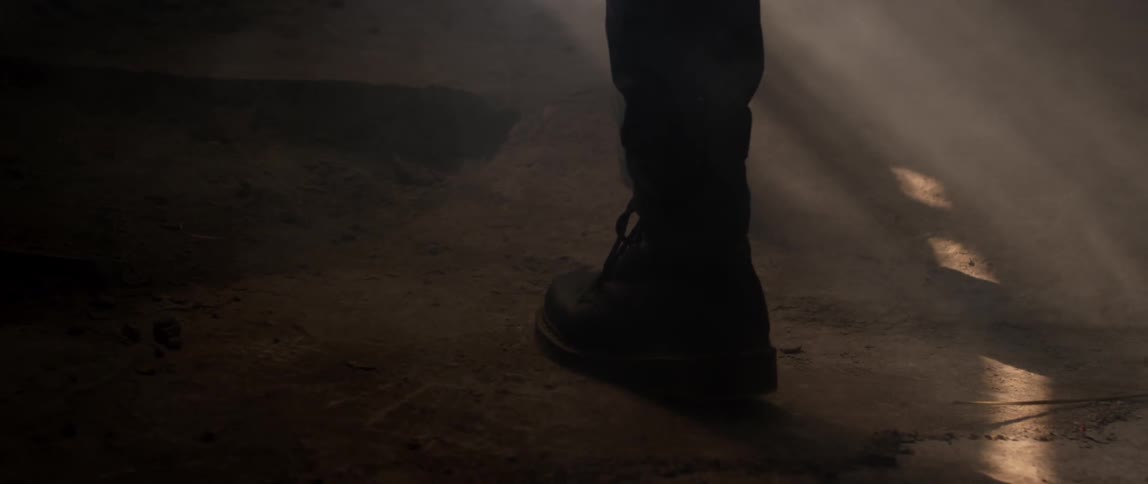 Sunlight highlights dust as a person walks by