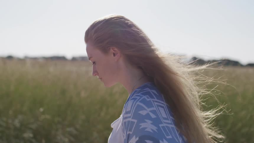 A woman walks outside in the breeze
