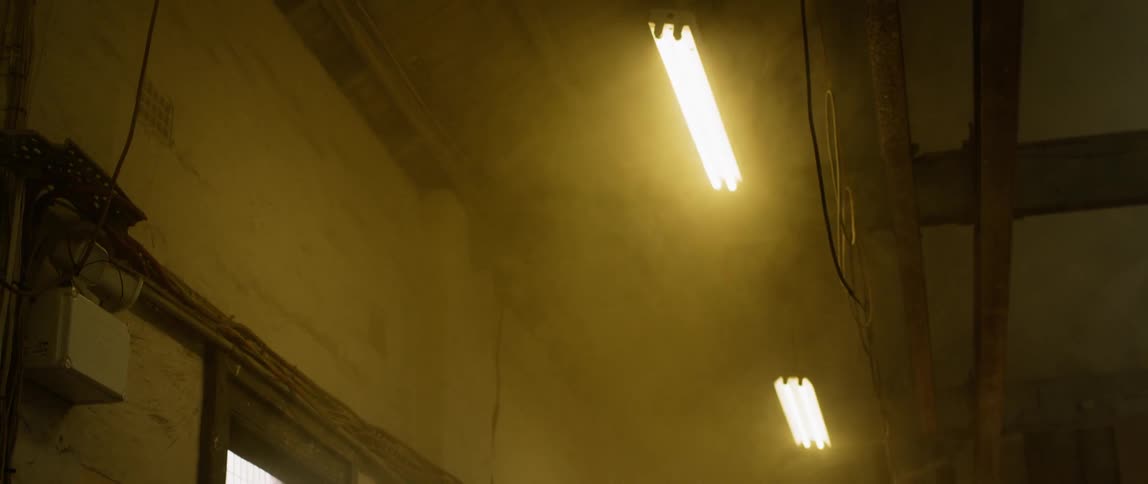 Fluorescent lights shine in a dusty building