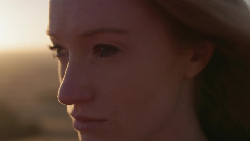 A woman's blond hair is blown by the wind