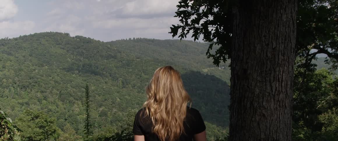 A woman looks out towards a valley