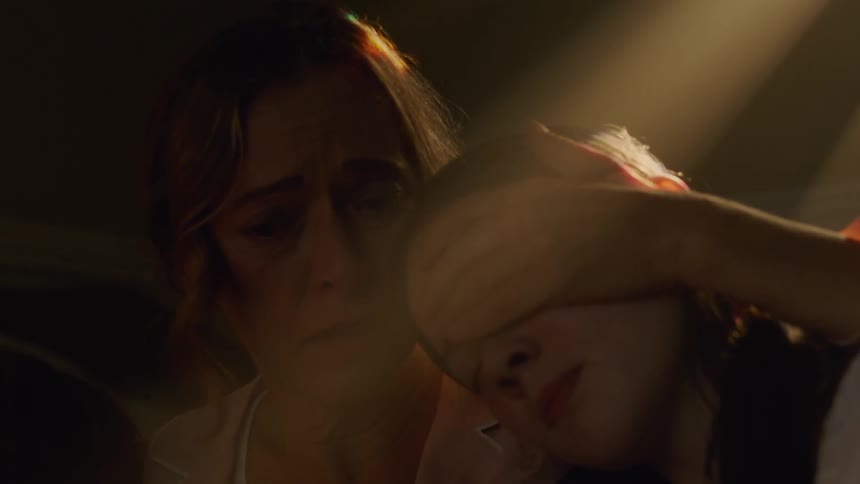 A mother looks worried while holding her children
