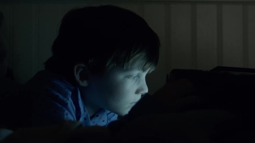 A young boy watches a small television