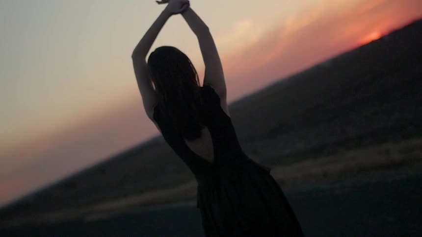 Woman standing in the road at dusk