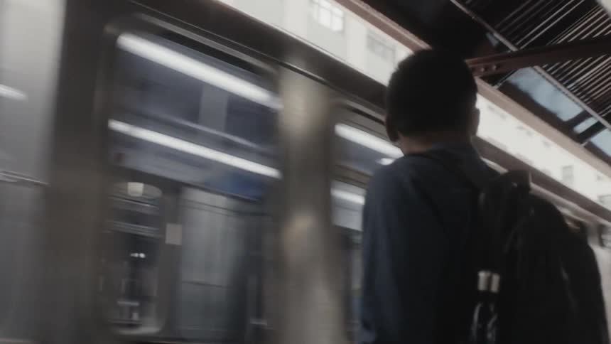 Train enters the train station and stops as passengers wait