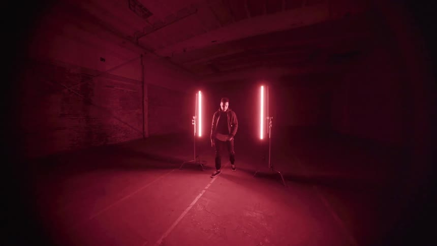 A man paces in a room with red lights