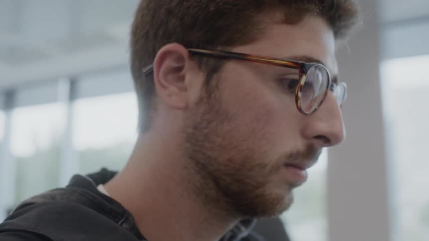 Man sitting at a desk looking at a laptop