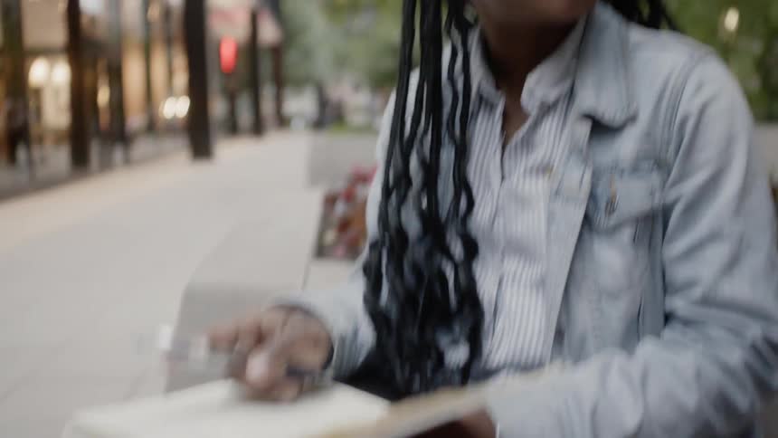 A woman is talking and writing outside
