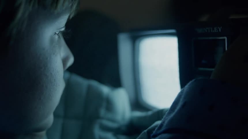 A young boy watches a small television